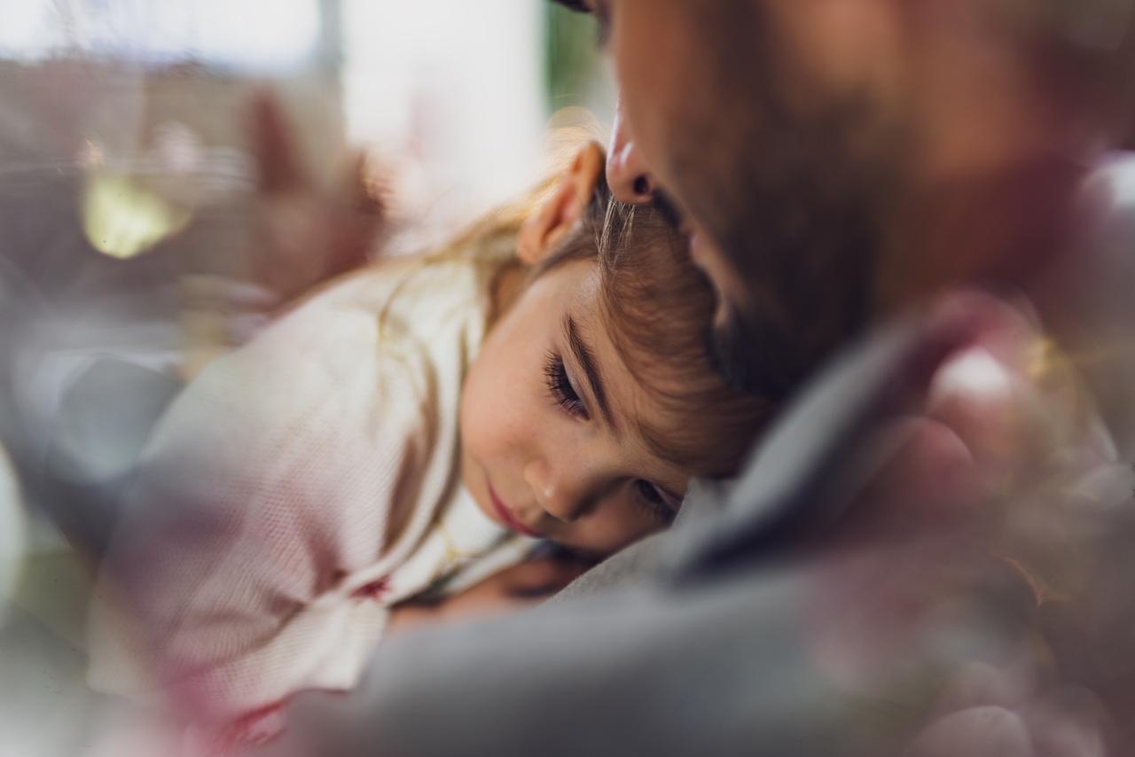 A parent holding a resting child.