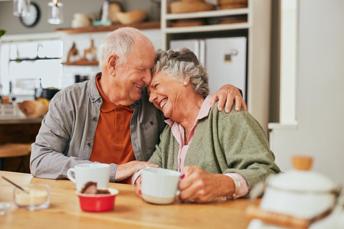 An older couple sitting together at home.